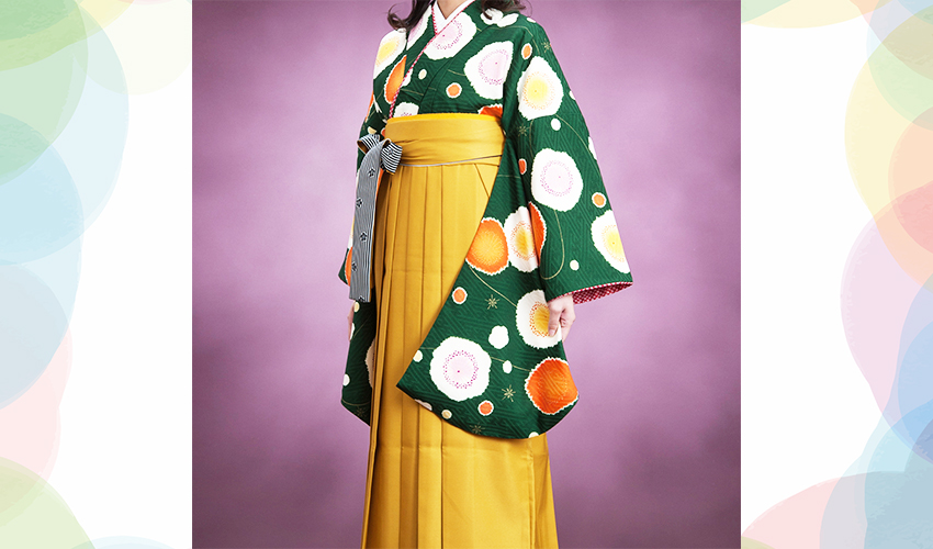 女性袴コレクション19。濃いグリンのレトロな柄の着物にカラシ色の袴のコーデ