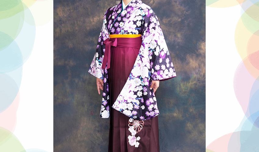 女性袴コレクション27。濃い紫地に白っぽい洋花の着物にワインぼかしの袴のコーデ